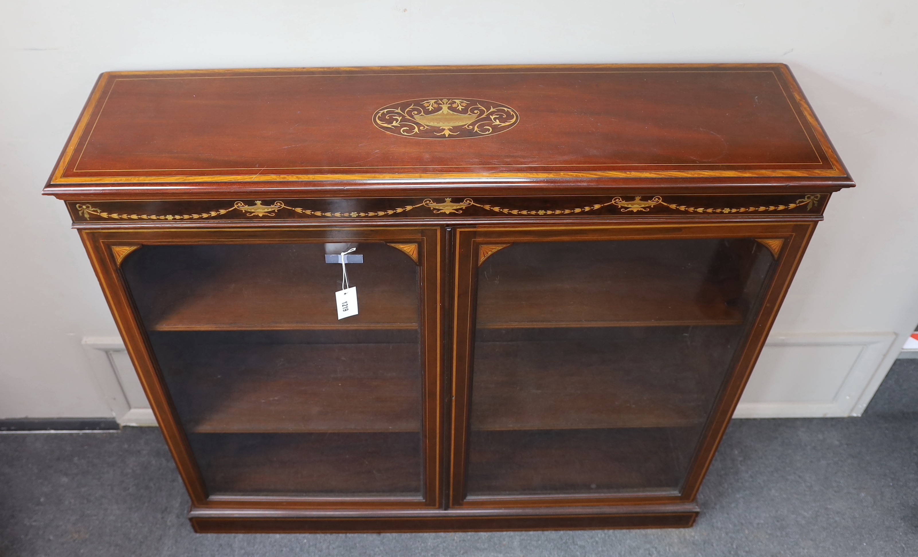 An Edwardian marquetry inlaid mahogany bookcase, bears Edwards & Roberts ivorine plaque, width 121cm, depth 31cm, height 111cm